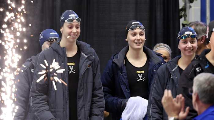 Virginia swimmers Gretchen Walsh, Alex Walsh, and Kate Douglass walk on the pool deck before a relay at the 2023 NCAA Swimming & Diving Championships in Knoxville, Tennessee.
